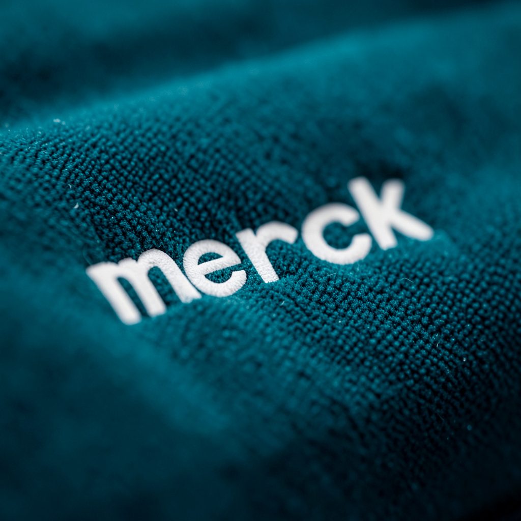 Merck corporate logo in dark charcoal on a cream background